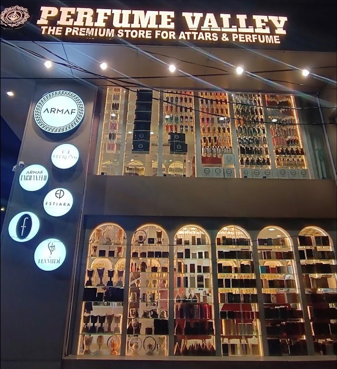 The Perfume Valley storefront in Hyderabad at night, with lit shelves of attars and perfumes